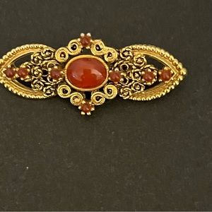Good preowned vintage gold tone, brooch with red center stone